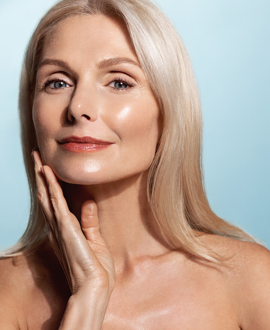 Woman with glowing skin touching her face