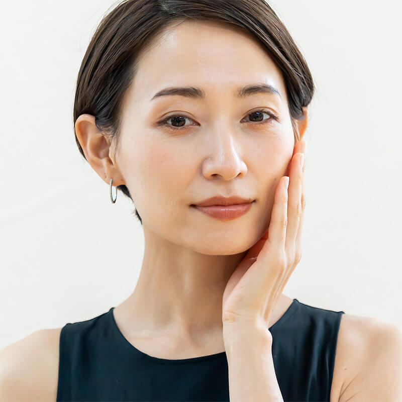 Mature asian woman touching her face